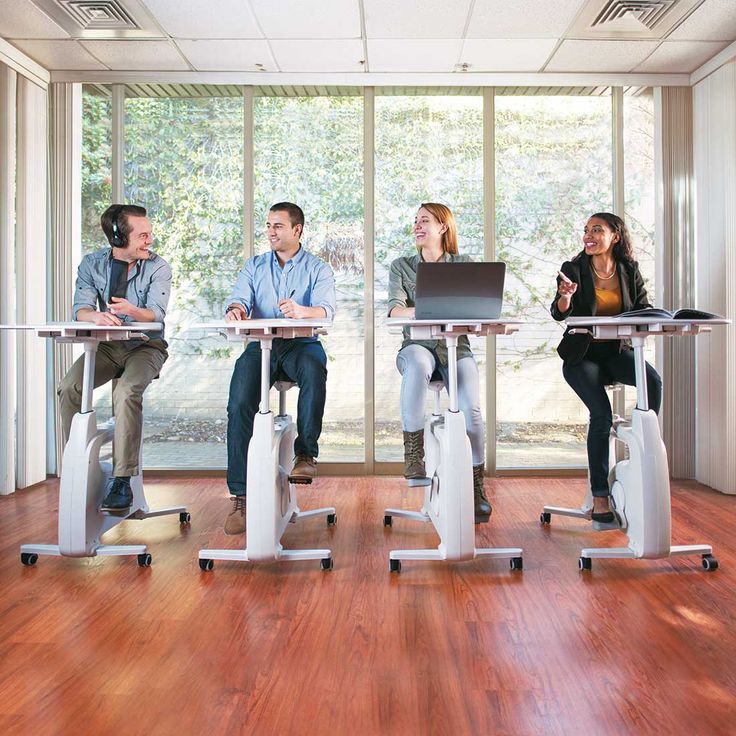 Colleagues taking a short standing stretch beside office desks