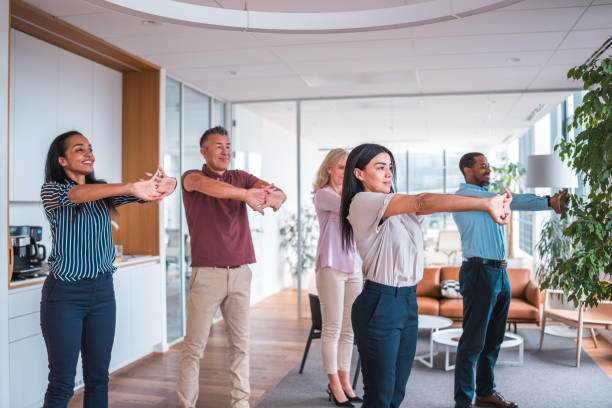 Small office team following a standing stretch led by a facilitator
